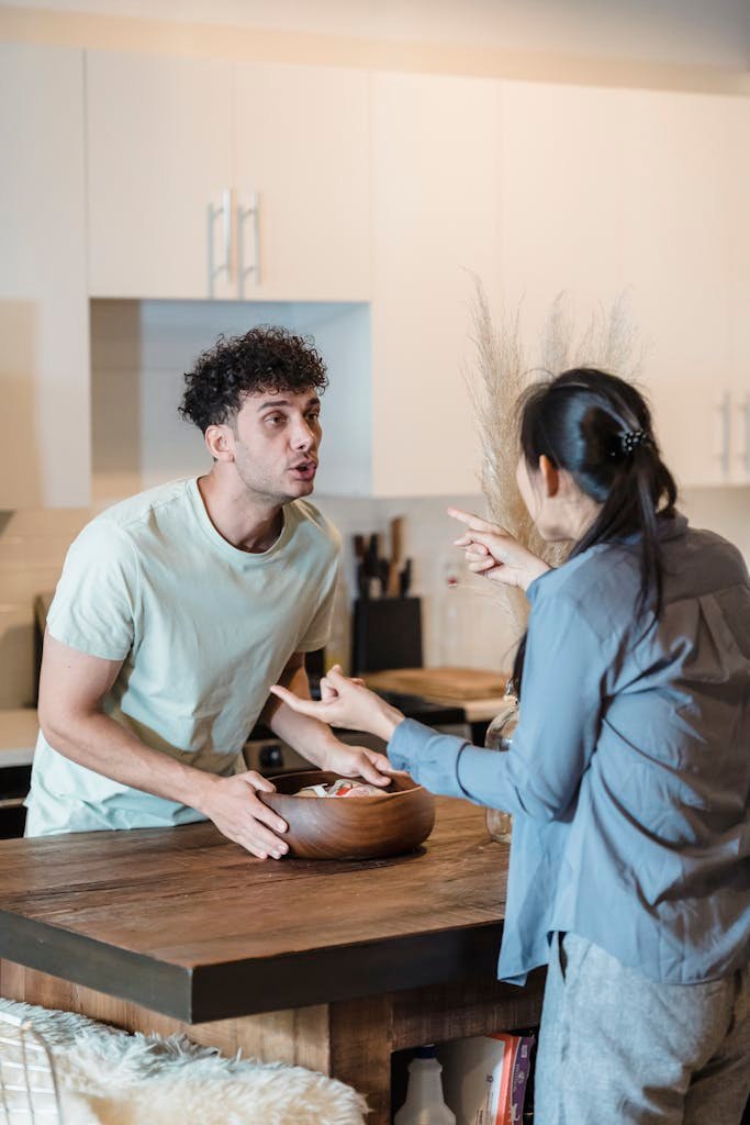 A couple engages in a heated discussion in a contemporary kitchen, highlighting relationship dynamics.