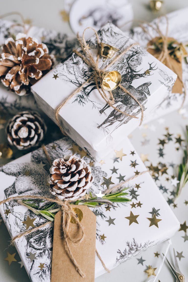 Elegant Christmas gifts wrapped with natural elements and star confetti for the festive season.